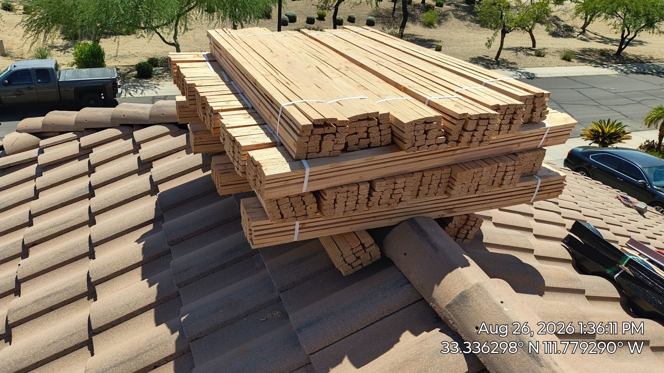 Lumber and batten delivery staged on tile roof